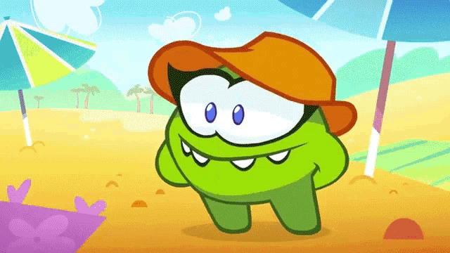 a green cartoon character wearing an orange hat stands on a beach