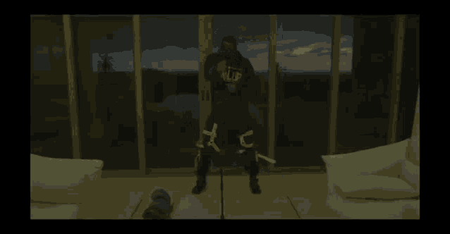 a man is standing in a living room in front of a sliding glass door .