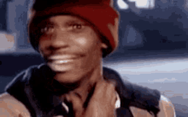 a close up of a man wearing a red beanie and a jacket .
