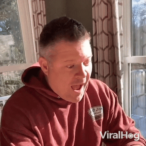 a man wearing a red sweatshirt that says g & n jones on the front