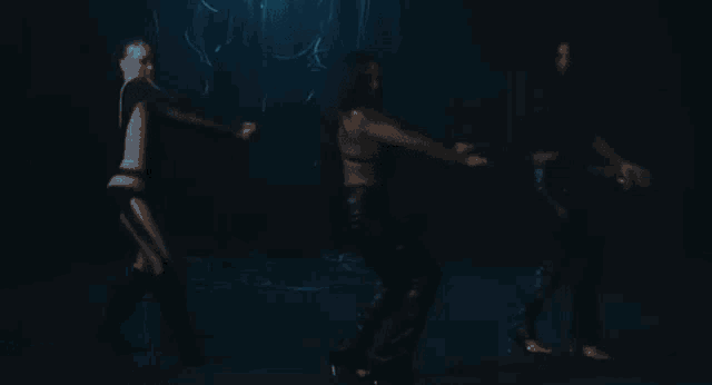 three women are dancing in a dark room with smoke coming out of it .