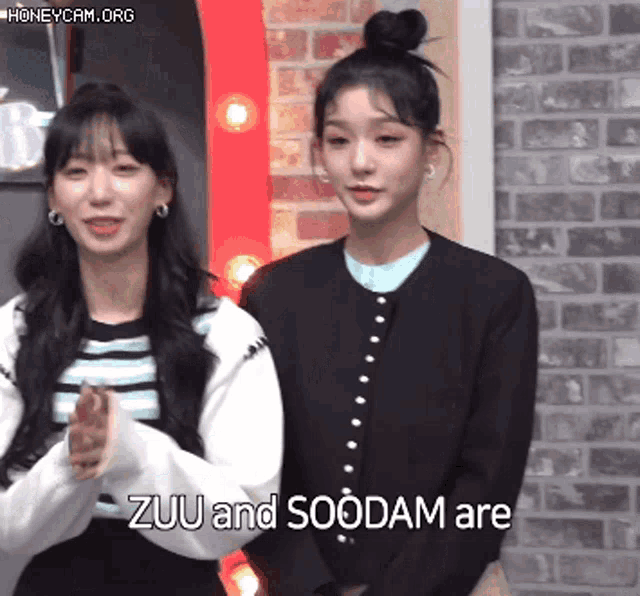 two women standing next to each other with the words " zuu and soodam are " visible