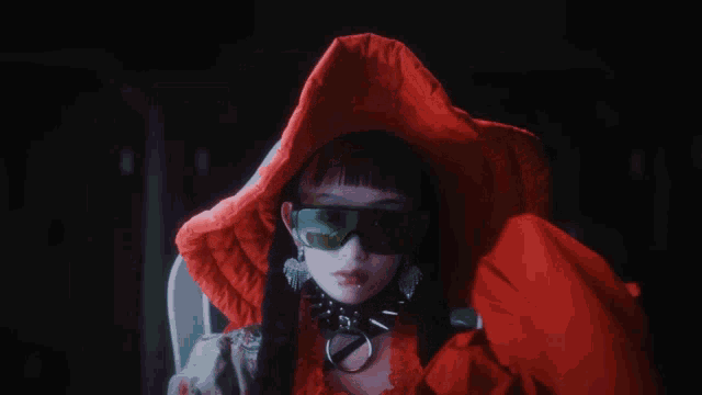 a woman wearing sunglasses and a red hooded jacket