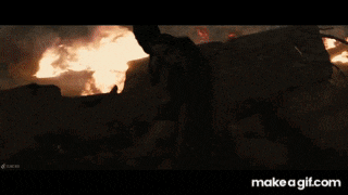 a man is standing in front of a burning building .