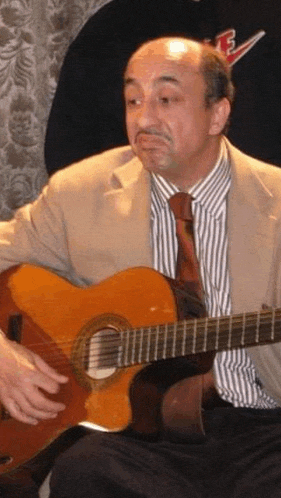 a man in a suit and tie playing a guitar