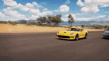 a yellow sports car is driving down the road