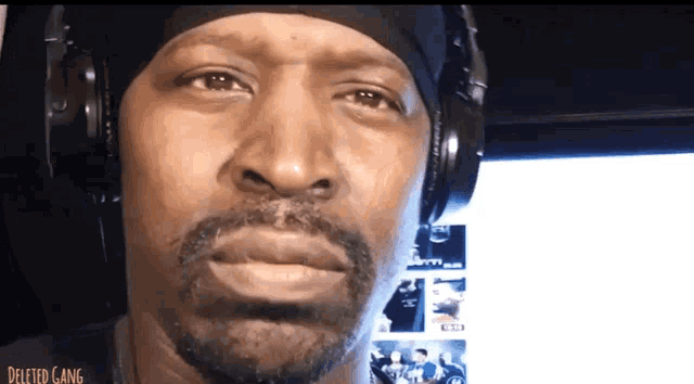 a man wearing headphones and a bandana with the word deleted gang written on it