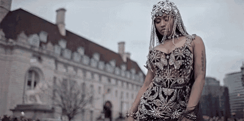 a woman in a fancy dress is standing in front of a large building .