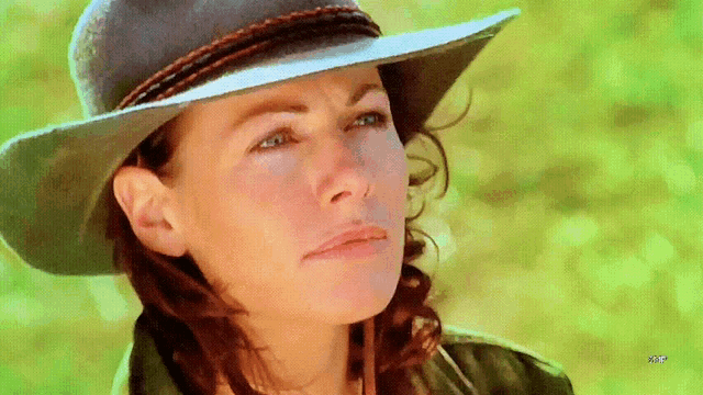 a woman wearing a cowboy hat is looking at something