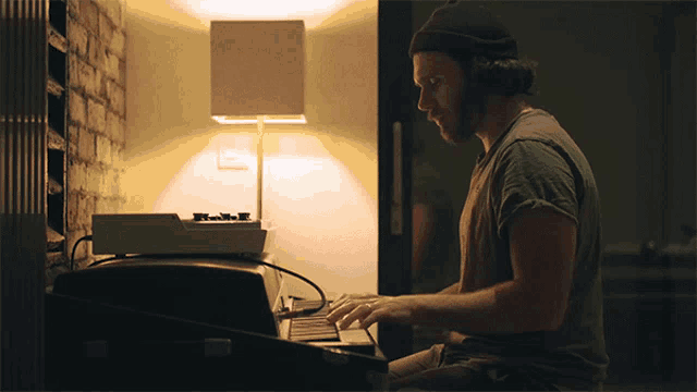 a man wearing headphones is typing on a computer keyboard