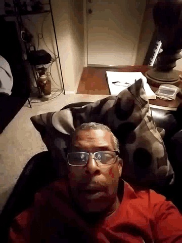a man with glasses is laying on a pillow