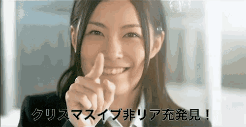 a woman in a suit and tie is smiling and pointing her finger at the camera .