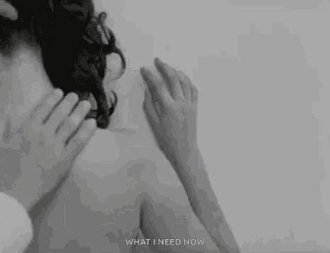 a black and white photo of a woman covering her face with her hands and the words `` what i need now '' .