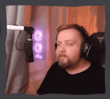 a man wearing headphones is sitting in front of a microphone ..