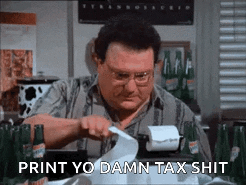 a man is sitting at a table with bottles of beer and a receipt printer .