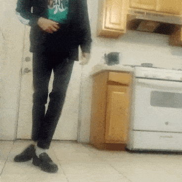 a person standing in a kitchen wearing a shirt that says ' abercrombie & fitch ' on it