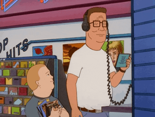 a man wearing headphones is standing in front of a store that says " top hits "