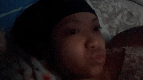 a woman laying on a bed with a black headband on