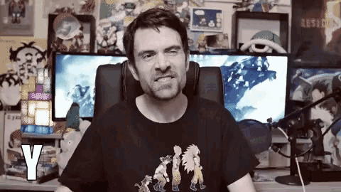 a man is sitting in front of a microphone wearing a black t-shirt that says y on it