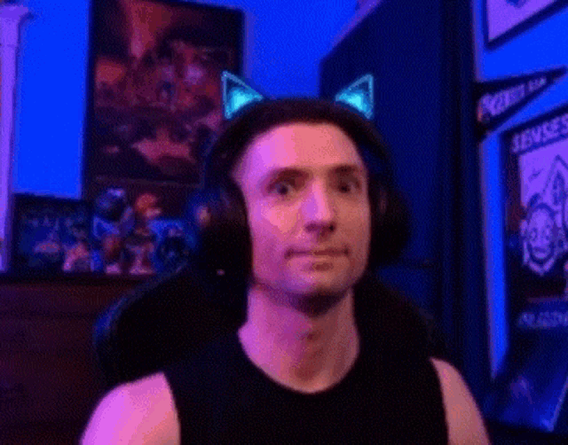 a man wearing headphones and cat ears is sitting in a chair in a room .