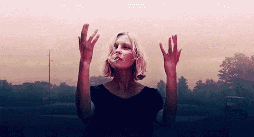 a woman is standing with her hands in the air .