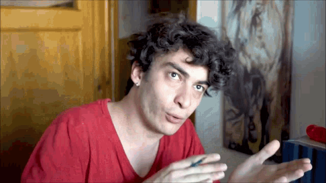 a man in a red shirt is making a funny face