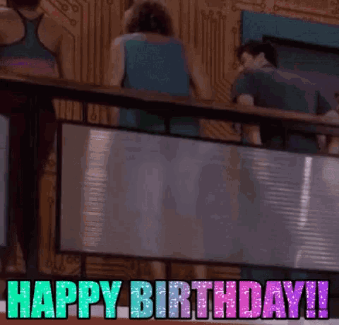 a group of people standing on a balcony with the words `` happy birthday ! '' written on it .