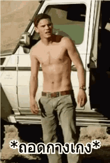 a shirtless man is standing in front of a white truck with the door open .