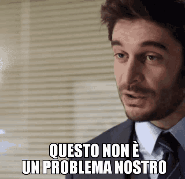 a man in a suit and tie is saying " questo non e un problema nostro "