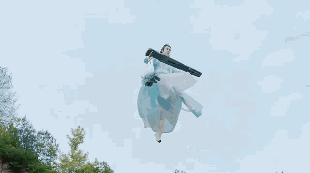 a woman in a blue dress is jumping in the air while holding a sword