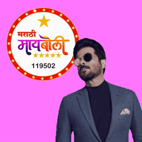 a man in a suit stands in front of a sign that says marathi mayboli 119502