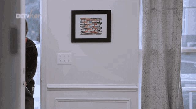 a framed picture hangs on a wall above a sign that says beta on it