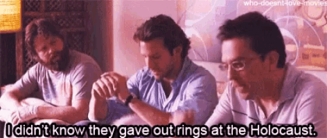 three men are sitting on a bed with one saying i did n't know they gave out rings at the holocaust ..