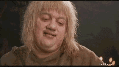 a man with blonde hair and a mustache is making a face .