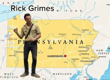 a man is standing in front of a map of sylvania with the name rick grimes on it