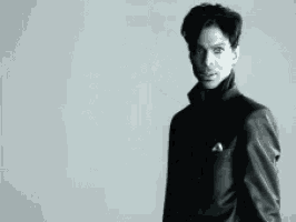 a black and white photo of a man in a black suit
