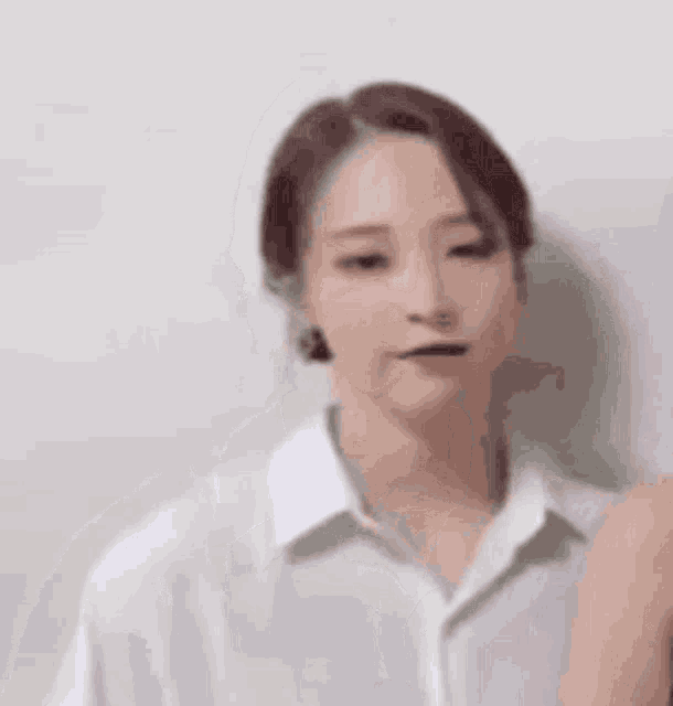 a woman in a white shirt is standing next to another woman and looking at the camera .