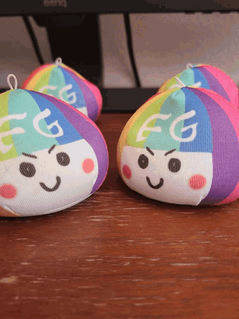 two stuffed toys with fg written on them sit on a wooden table