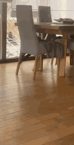 a wooden table and chairs in a room with a window