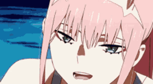 a close up of a girl with pink hair and green eyes looking at the camera .