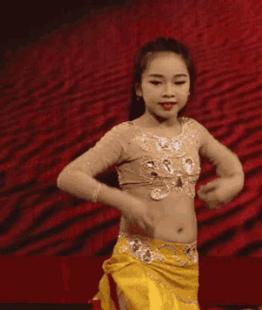 a young girl in a yellow skirt is dancing