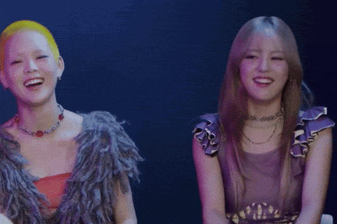 two women are sitting next to each other and one has yellow hair