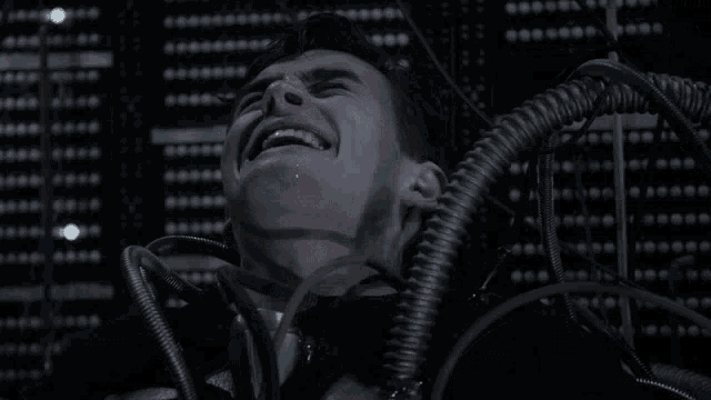 a man is screaming while surrounded by wires and cables