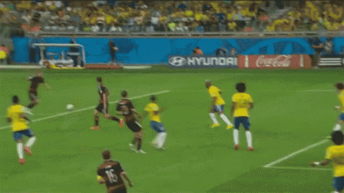 a soccer goalie dives to catch a ball in front of a budweiser ad