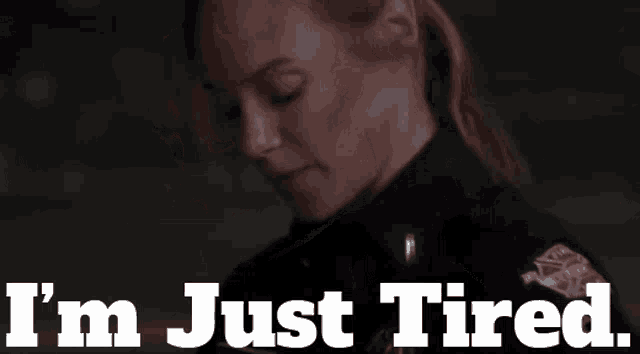 a woman in a police uniform with the words i 'm just tired behind her
