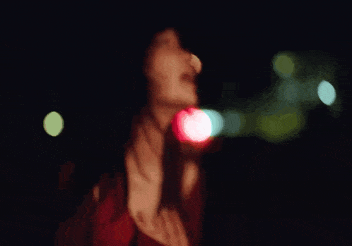 a woman is playing a guitar in front of a red background