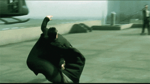 a man in a black cape is being thrown in the air by a helicopter