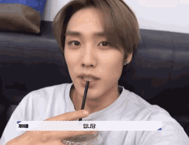 a close up of a person drinking through a straw with korean writing on it