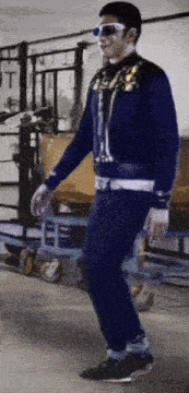 a man wearing sunglasses and a blue jacket is dancing