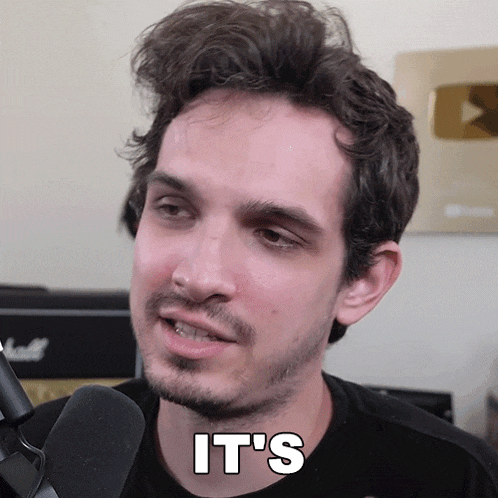 a man with a beard is talking into a microphone with the words it 's on his face